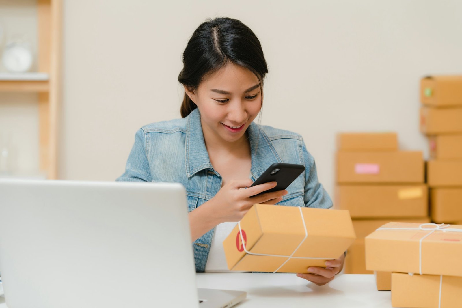 Online seller checking orders next to packed parcels