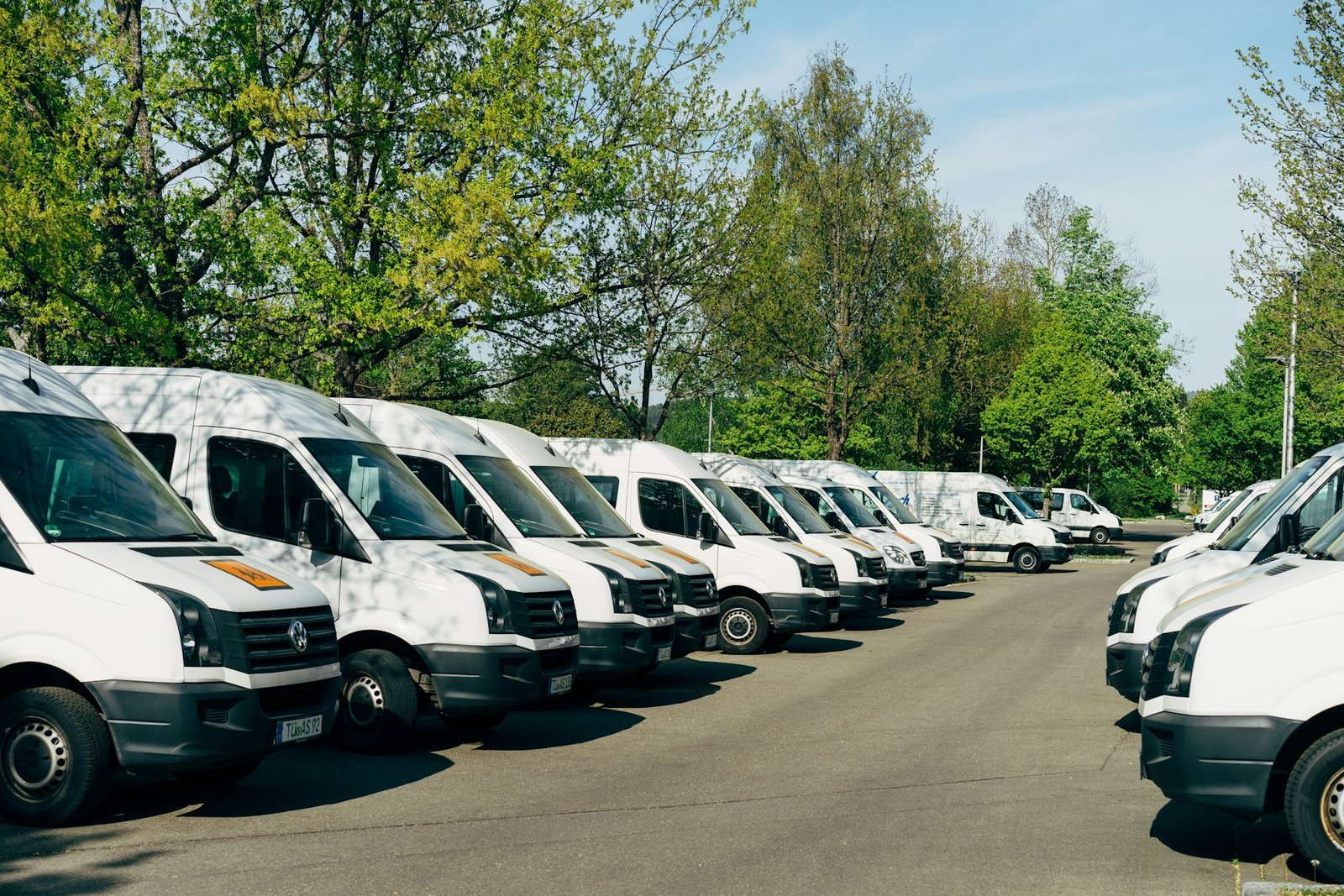 Fleet of white courier vans parked in a row